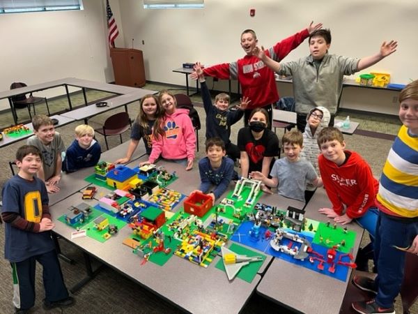 kids posing around a table of their Lego creations